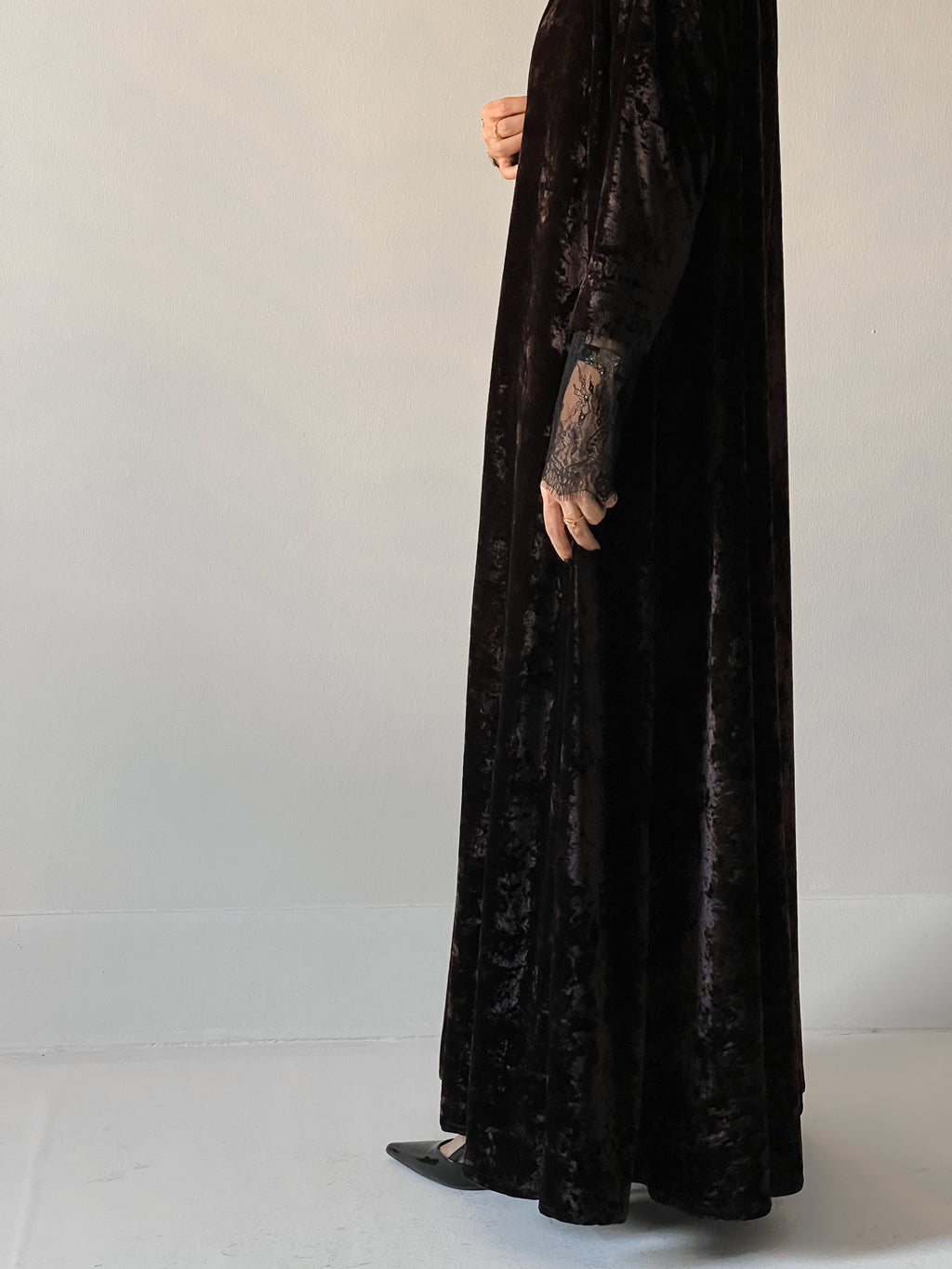 An elegant black abaya crafted from soft velvet fabric, finished with delicate lace detailing on the sleeves for a timeless and feminine look.