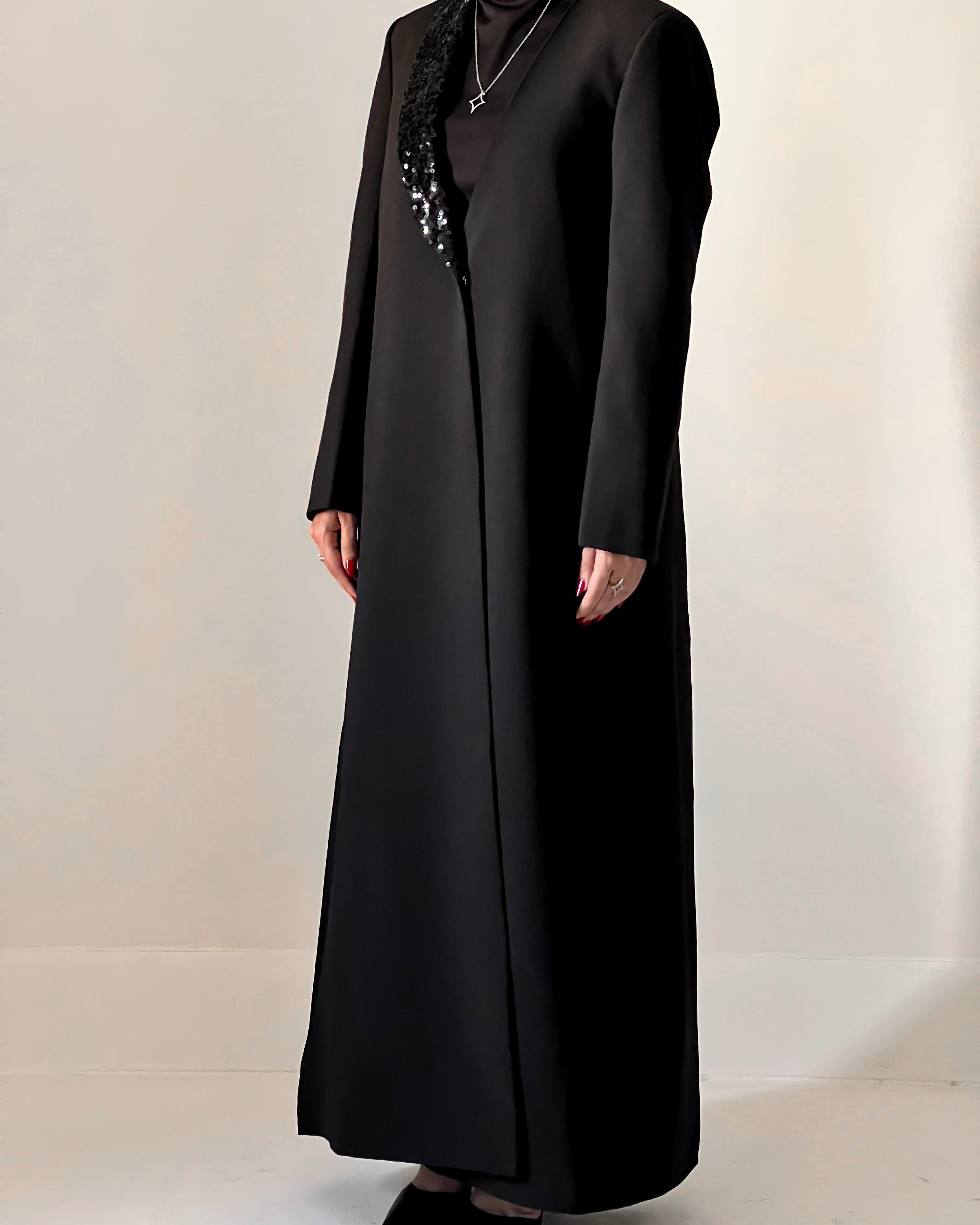 Blazer cut abaya crafted from premium crepe, finished with a sequin detailed on one side collar.